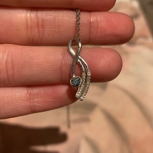 Silver ribbon pendant with green and white gems